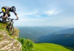 Biker riding down green mountains