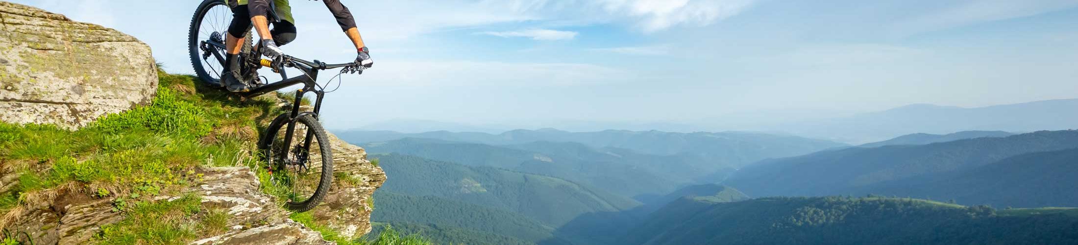 Biker riding down green mountains