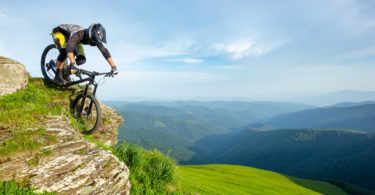 Biker riding down green mountains