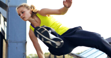 Woman jumping over rail