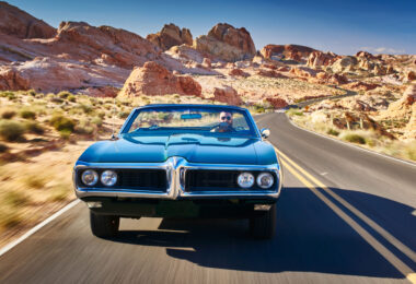 Man driving car desert road